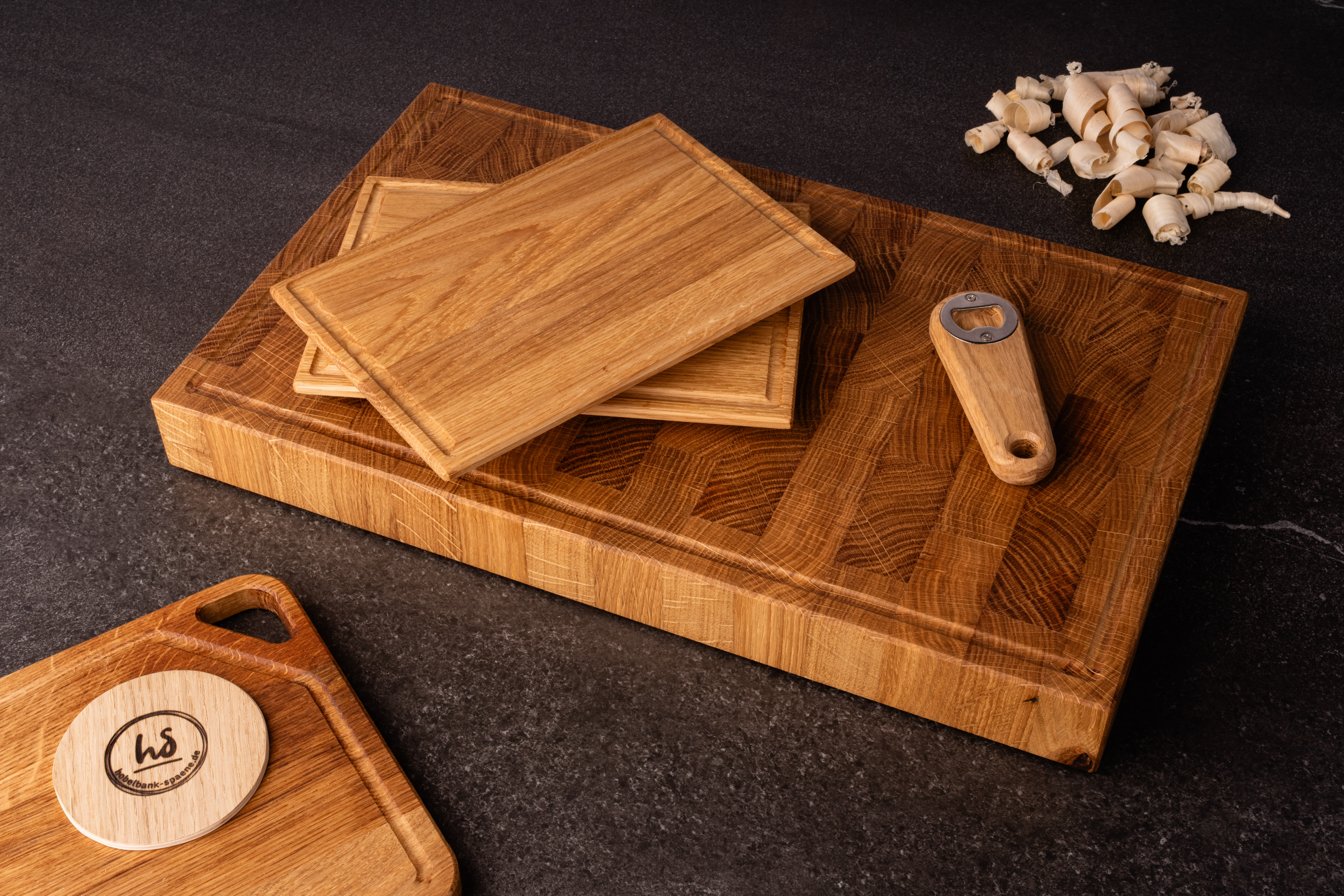 Handgefertigte Schneidebretter mit Flaschenöffner auf dunklem Steinhintergrund